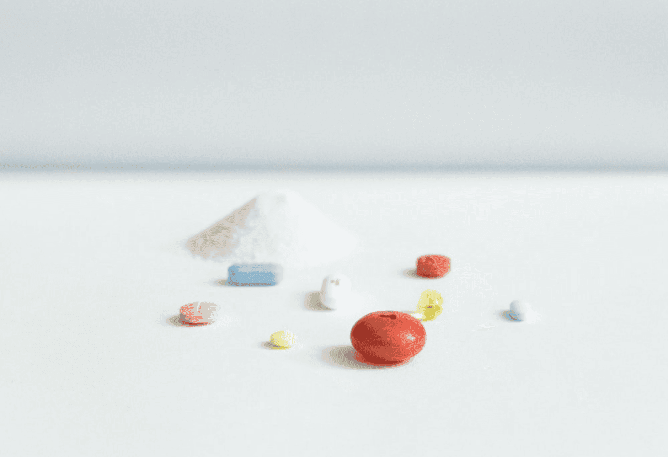 Weißes Pulver neben Tabletten und Kapseln